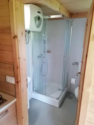 a shower with a glass door in a bathroom at Jelenova lesena hiška in Loče pri Poljčanah