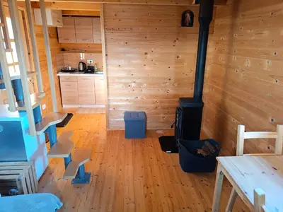 a room with a woodburning stove in a cabin at Jelenova lesena hiška in Loče pri Poljčanah