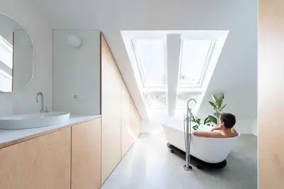 a man sitting in a bath tub in a bathroom at Sheila's Loft in Ljubljana