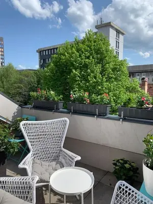 a patio with two chairs and a table and some plants at Sheila's Loft in Ljubljana