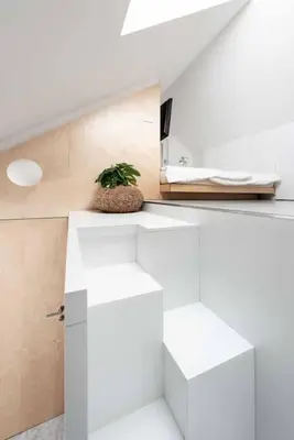 a white kitchen with a plant sitting on a counter at Sheila's Loft in Ljubljana
