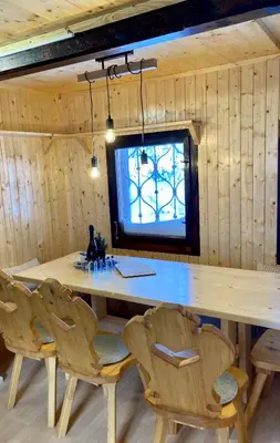 a dining room with a large wooden table and chairs at Chalet Korosica Velika Planina in Stahovica