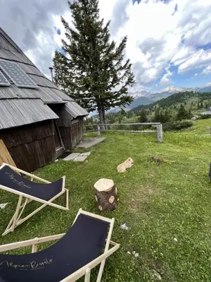 two chairs sitting in a yard next to a barn at Chalet Korosica Velika Planina in Stahovica