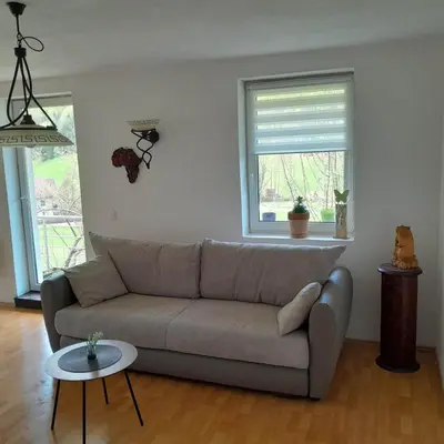 a living room with a couch and a window at Nice Apartment near by Capital of Slovenia in Ljubljana