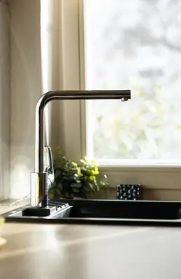 a kitchen sink with a faucet and a window at Central apartment great for couples or small families in Ljubljana