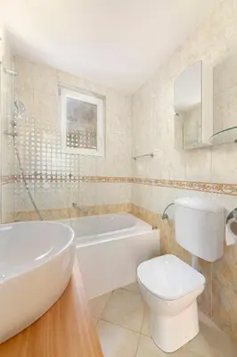 a bathroom with a tub and a toilet and a sink at Lakeview Bled Heaven Apartments in Bled
