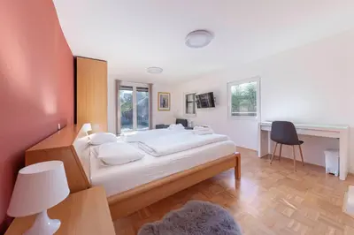 a bedroom with a bed and a desk with a chair at Lakeview Bled Heaven Apartments in Bled