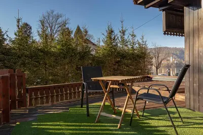 a wooden table and two chairs on a deck at Lakeview Bled Heaven Apartments in Bled