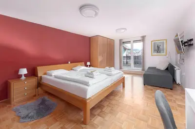 a bedroom with a large bed and a red wall at Lakeview Bled Heaven Apartments in Bled