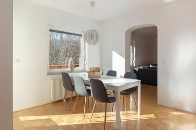 a dining room with a white table and chairs at Lakeview Bled Heaven Apartments in Bled