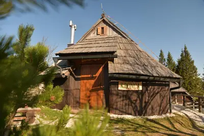 a large wooden barn with a sign on it at Koča Kronca - Velika planina in Stahovica