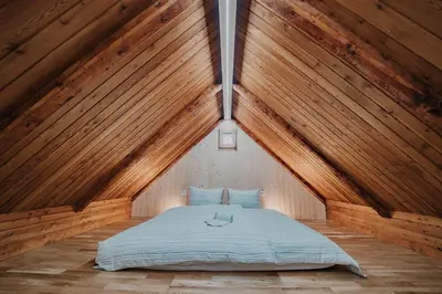 a bedroom with a bed in a wooden ceiling at Koča Kronca - Velika planina in Stahovica