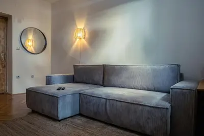 a living room with a couch and a mirror at Cactus apartment FREE parking for a standard car in Ljubljana
