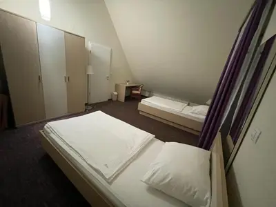 a hotel room with two beds and a mirror at Family Apartments Terme Topolšica - Pušpan in Topolšica