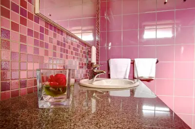 a pink bathroom with a sink and a vase with a flower at Family Apartments Terme Topolšica - Pušpan in Topolšica
