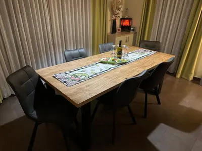 a wooden table with chairs around it with a table cloth on it at Family Apartments Terme Topolšica - Pušpan in Topolšica