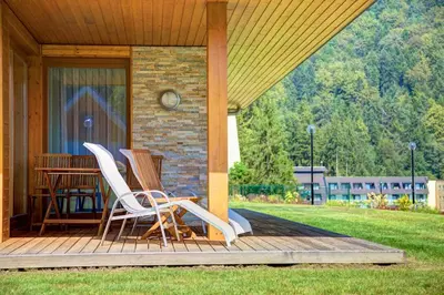 two chairs and a table on a porch of a house at Family Apartments Terme Topolšica - Pušpan in Topolšica