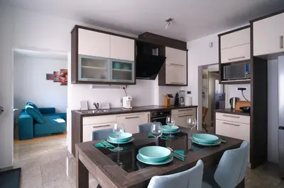 a kitchen with a wooden table with chairs and a dining room at Apartment Kamnik-apartment with a large terrace in Kamnik