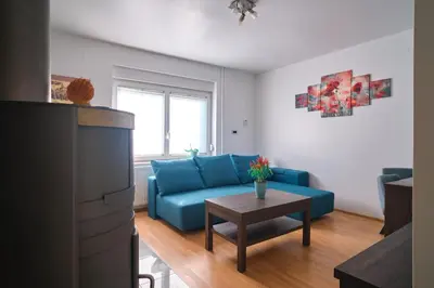 a living room with a blue couch and a table at Apartment Kamnik-apartment with a large terrace in Kamnik