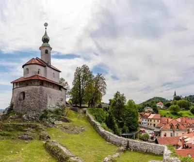 an old castle on a hill with a town in the background at Apartment Kamnik-apartment with a large terrace in Kamnik