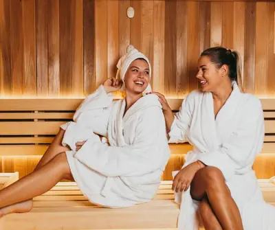 two women in towels sitting on a bed at Apartment Kamnik-apartment with a large terrace in Kamnik