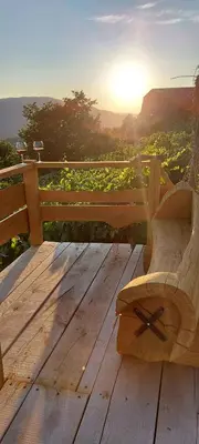 a wooden bench sitting on a wooden table with the sunset at Holiday home in Drganja sela Kranjska Krain 42002 in Drganja Sela