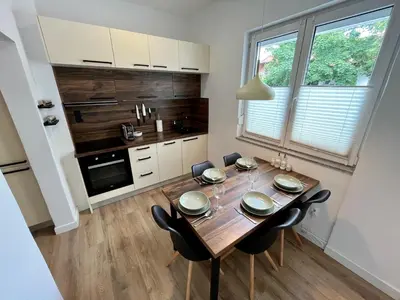 a kitchen with a wooden table and black chairs at Apartment TiSa, Ljubljana in Ljubljana