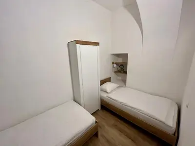 two beds in a small room with white walls at Apartment TiSa, Ljubljana in Ljubljana