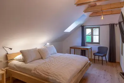 a bedroom with a bed and a desk and a window at Villa Richterberg with Sauna & Hot Tub in Slovenj Gradec