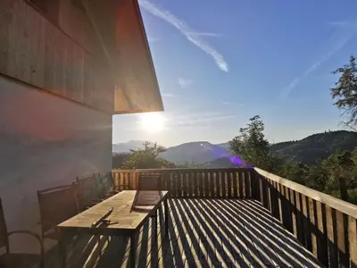a wooden deck with a bench on the side of a house at Villa Richterberg with Sauna & Hot Tub in Slovenj Gradec
