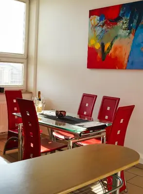 a dining room with red chairs and a table and a painting at Apartment Ken near Terme Paradiso in Dobova