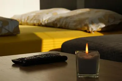 a candle and a remote control sitting on a table at Apartment Ken near Terme Paradiso in Dobova