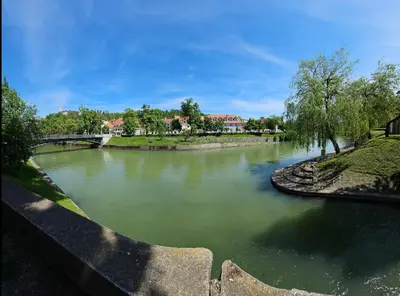 a body of water with a bridge and trees at Cozy Nest in Ljubljana
