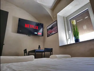 a bedroom with a bed and a television on the wall at Cozy Nest in Ljubljana
