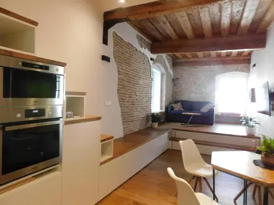 a kitchen and living room with a table and chairs at Boutique Apartment Križanke in Ljubljana
