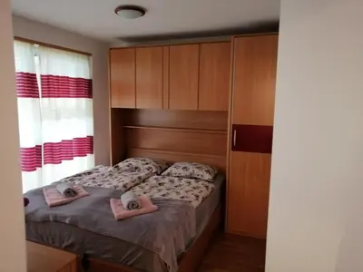 a bedroom with two beds with pink slippers on them at Apartma Vita in Moravske Toplice