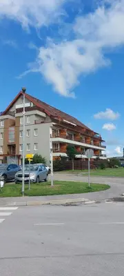a large building with cars parked in front of it at Apartma Vita in Moravske Toplice