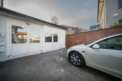 a white car parked in front of a garage at P & B Apartment in Ljubljana