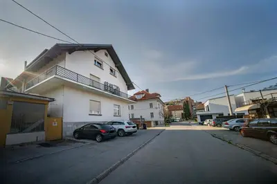 a parking lot with cars parked in front of a building at P & B Apartment in Ljubljana