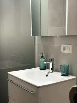 a bathroom sink with a green container on it at Apartment Vita in Bovec