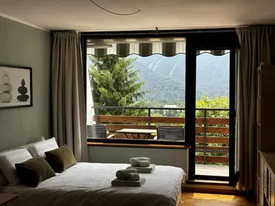 a bedroom with a bed and a large window at Apartment Vita in Bovec