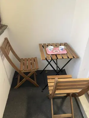 a table and a chair next to a table with two cups at Brasilia apartment in Ljubljana
