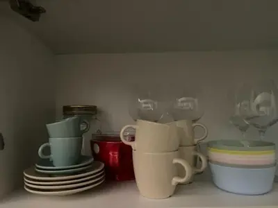 a shelf with cups and plates and wine glasses at Brasilia apartment in Ljubljana
