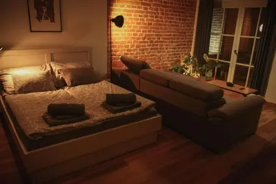 a bedroom with a bed and a couch and a window at Grossmann Apartment in Ljutomer