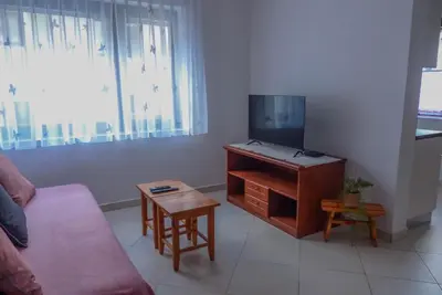 a living room with a couch and a tv and a table at Apartma Praprot in Mojstrana