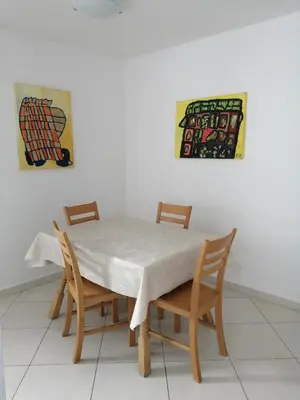 a dining room table with four chairs and a painting at Apartma Praprot in Mojstrana