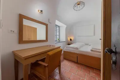a bedroom with a desk and a bed with a mirror at Apartma Jenkova rezidenca in Kranj