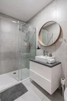 a bathroom with a shower and a sink and a mirror at Classy & Cozy apartment in Ljubljana