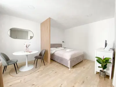 a bedroom with a bed and a table and chairs at Classy & Cozy apartment in Ljubljana