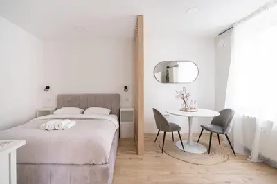 a bedroom with a bed and a table and chairs at Classy & Cozy apartment 2 in Ljubljana